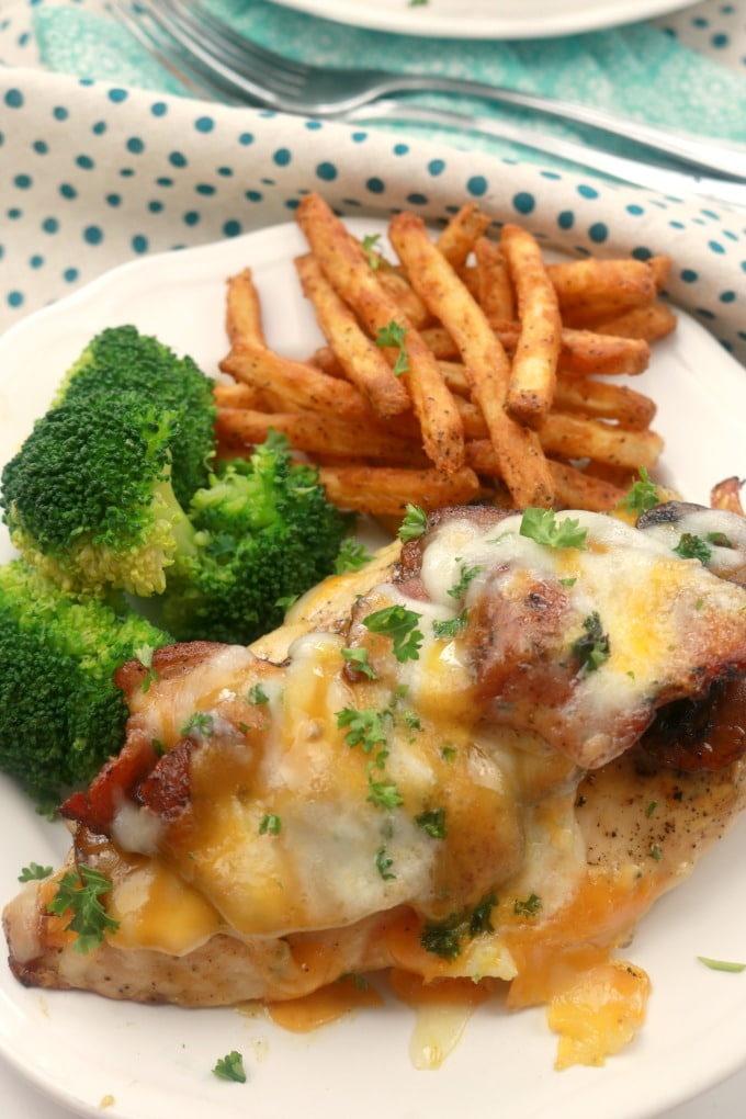 A close-up photo of alice springs chicken plated with steamed broccoli and french fries.