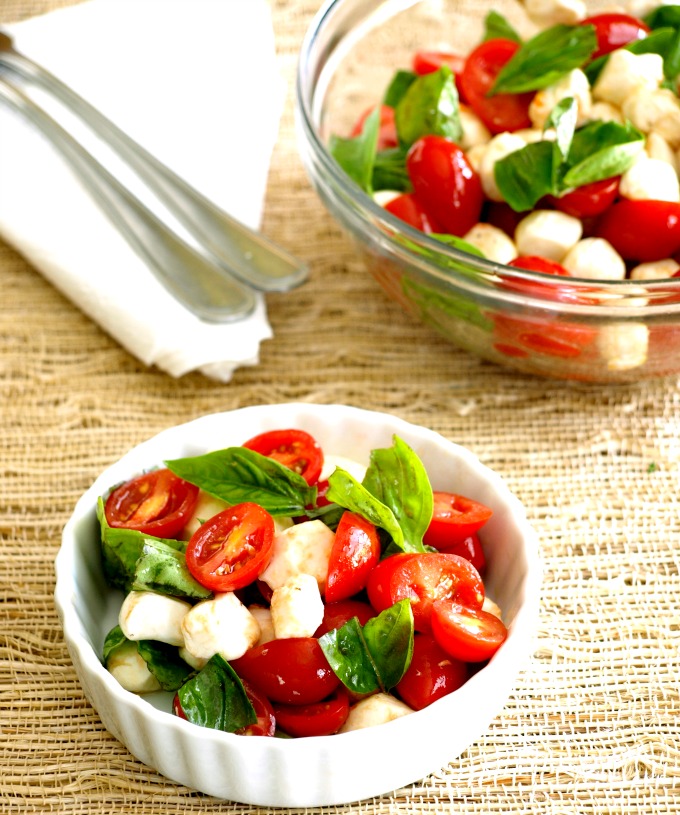 A bowl of Caprese Salad on a woven placemat