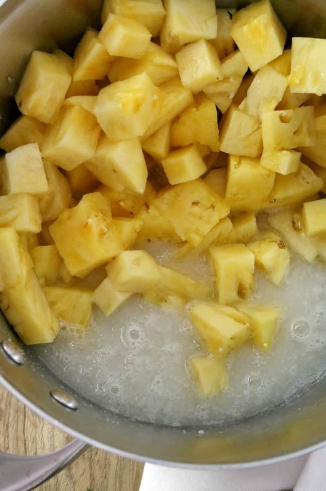 An image showing the ingredients for fresh pineapple jam in a stockpot. 