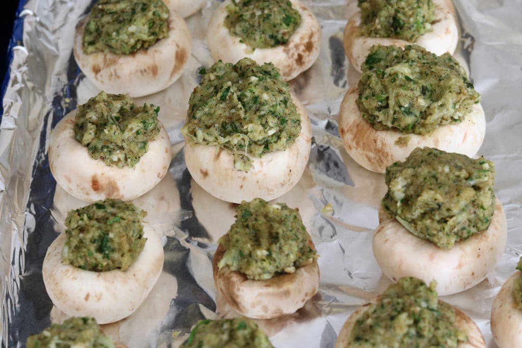 A tray of cremini mushrooms stuffed with vegetarian cheesy herb breadcrumb filling.