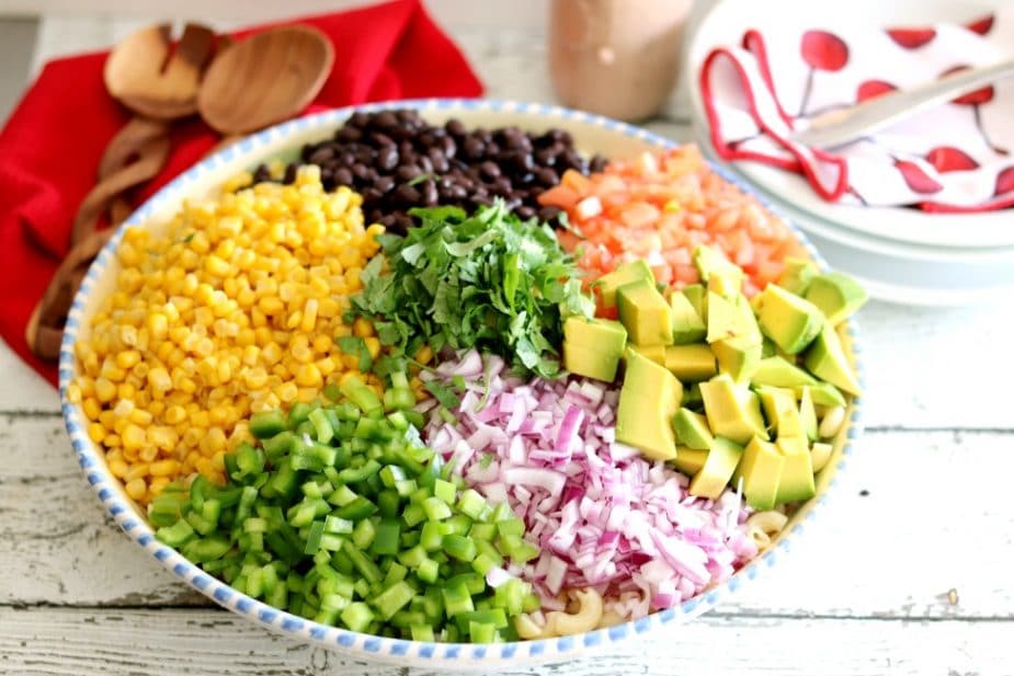 The ingredients for Mexican Macaroni salad in a bowl ready to be tossed with dressing.