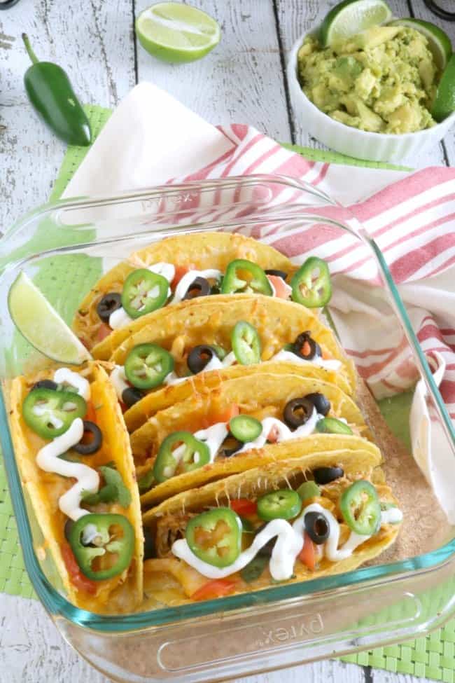 Tender and juicy Shredded Mexican Style Chicken is layered into crispy Taco shells, topped with shredded cheese and baked to golden perfection in the oven to create these Baked Chicken Tacos. What my family loves about it is that we can each add just whatever toppings we like in any quantity we chose. YUMM! 