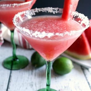 two glasses of watermelon margaritas served with a salted rim and a watermelon slice.