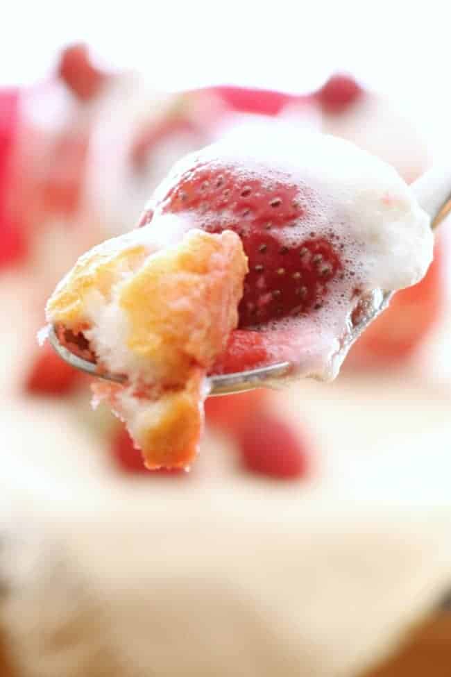 A bite of strawberry shortcake trifle on a spoon.