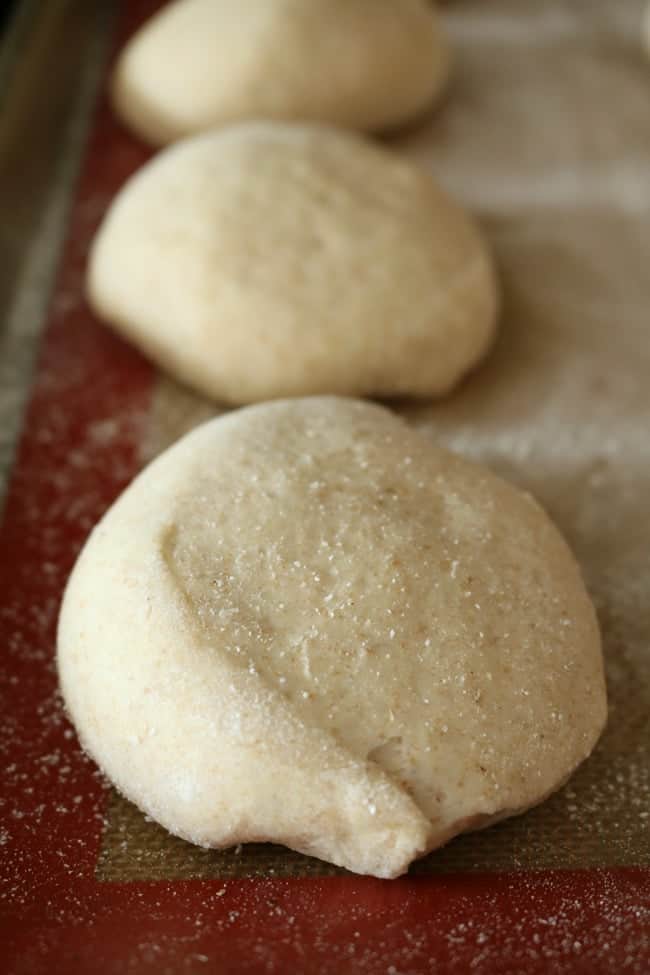 English muffin dough rising on a coated silicone liner.
