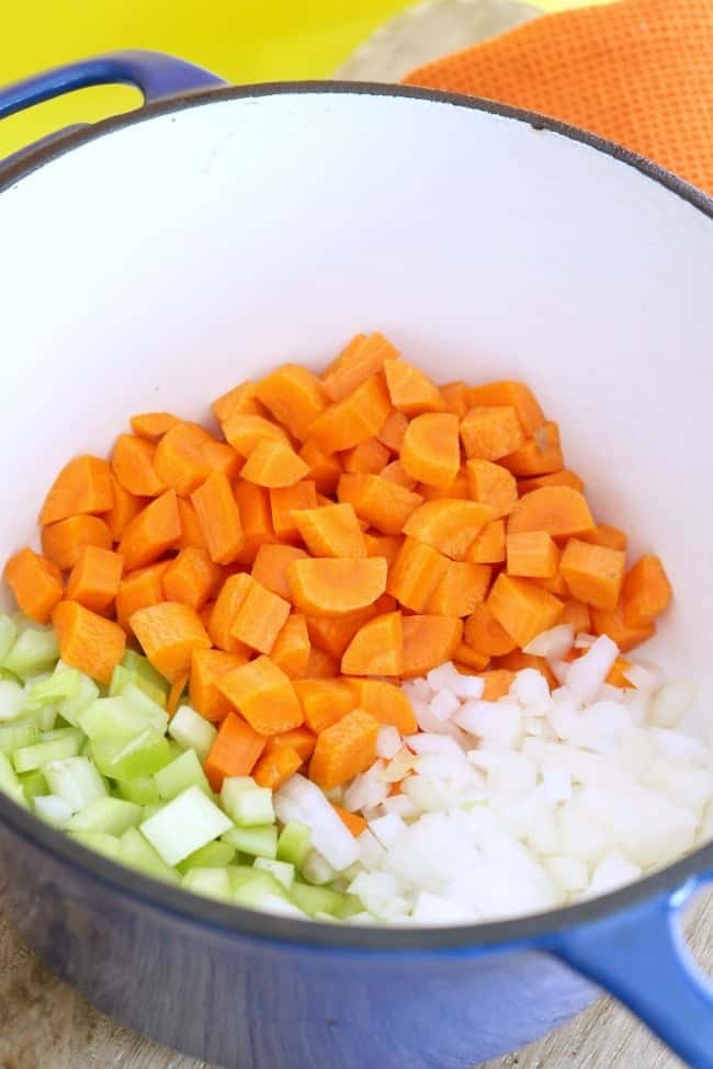 Carrots, celery, and onion being browned in a Dutch oven.