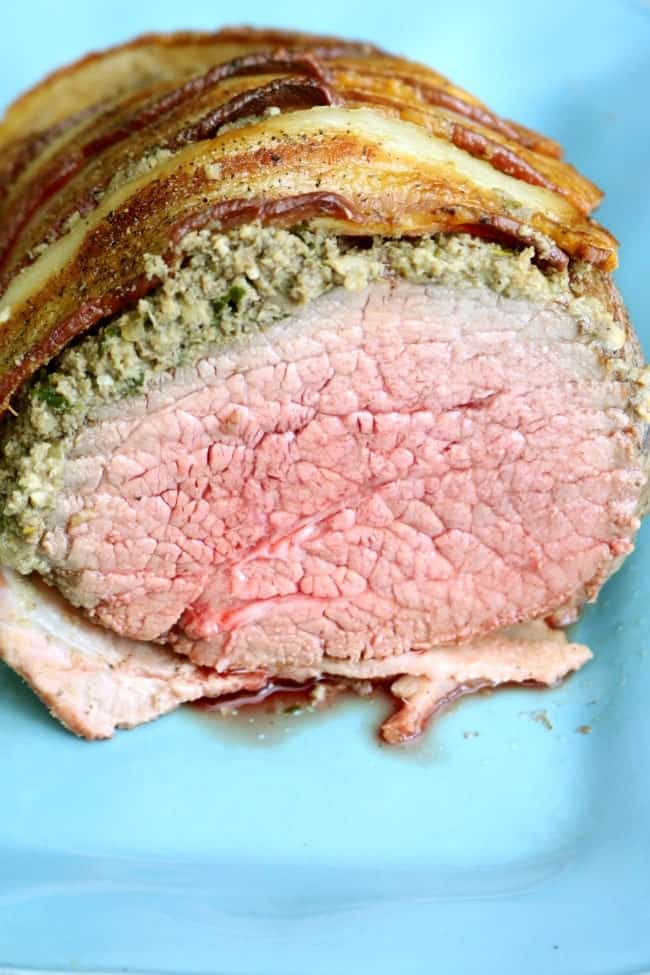 an roasted eye of round sliced open to show a beautiful medium-rare center