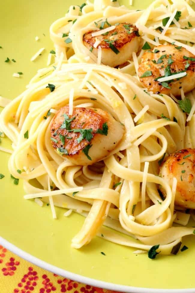 A plate of lemon-garlic pasta with pan-seared scallops. 