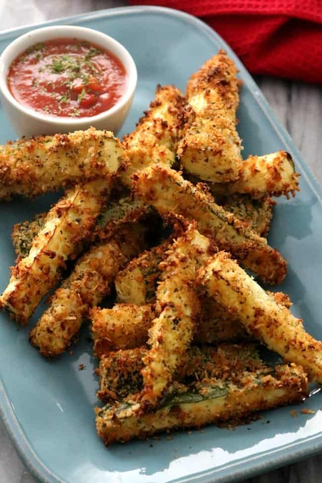 Baked Parmesan Zucchini Fries are a great no-fuss way to get kids (and adults) to eat their vegetables. Crisp on the outside and creamy on the inside with a nice bit of saltiness from the Parmesan cheese these fries are your new favorite way to eat zucchini. Served with a marinara, these make a great kid friendly and figure-friendly appetizer or side dish.