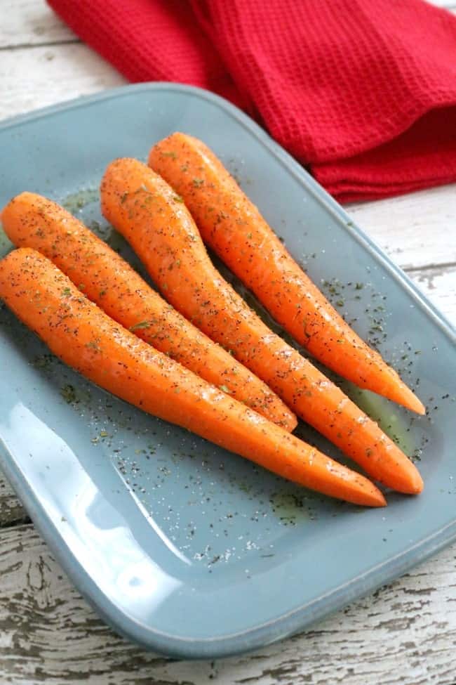 a plate of carrots ready to be roasted. Easy Oven Roasted Carrots are the perfect side for weeknight meals and holiday dinners.