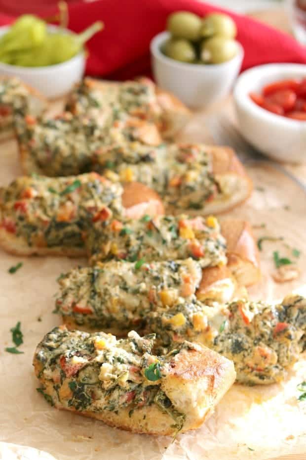 Spinach Dip Stuffed French Bread is hot and melty, ooey and gooey, carb-y and delicious. That's why Spinach Dip stuffed French Bread is the perfect party appetizer! #Party #Appetizers #Vegetarian #Holiday #Ideas
