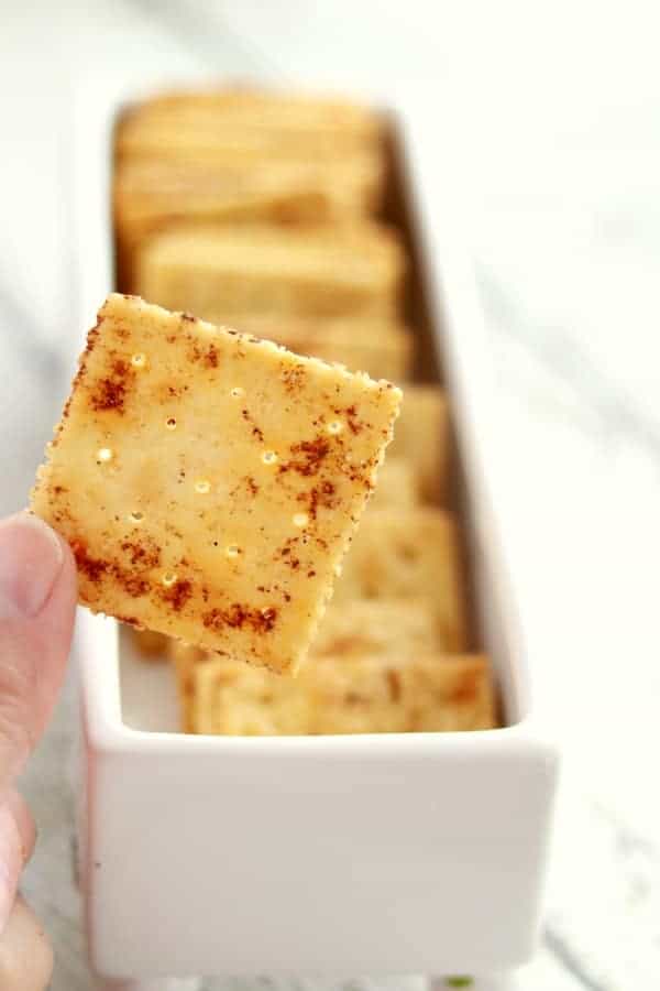 A tray of seasoned crackers with a close up of a single cracker in focus.