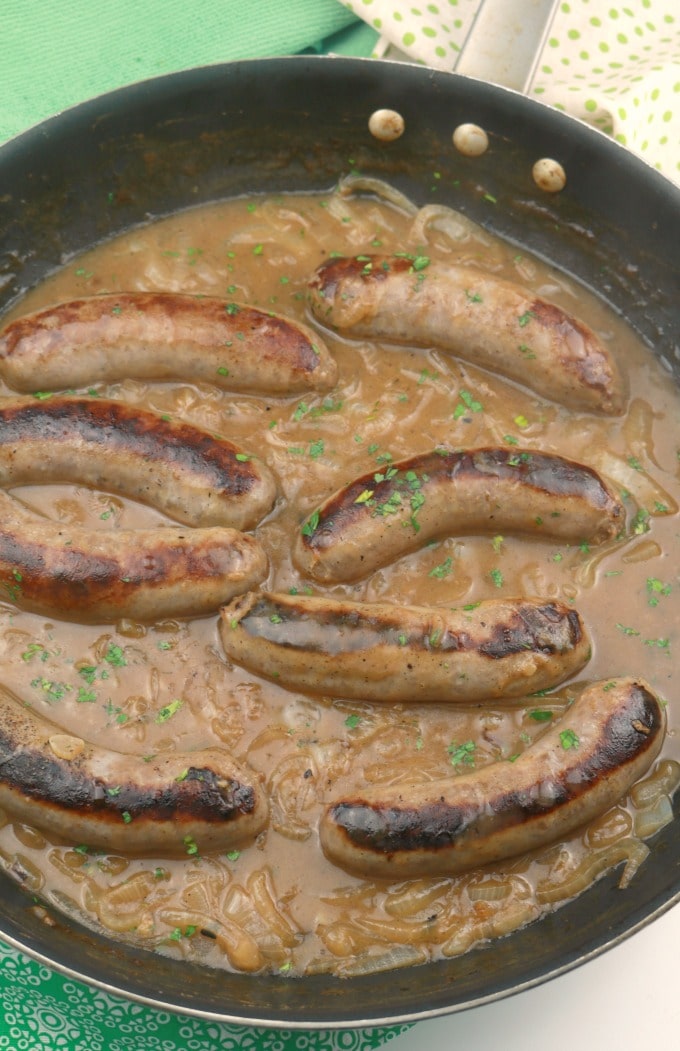 A pan of sausages that have been simmered in onion ale gravy