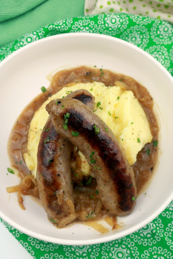 A bowl of bangers and mash in onon ale gravy