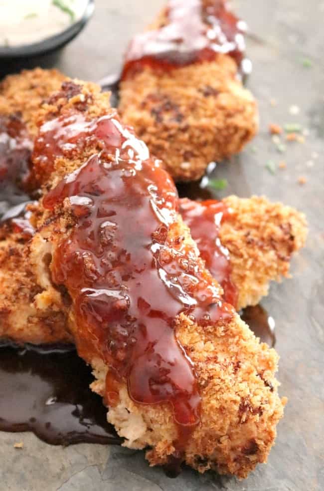 A close-up shot of chicken tenders coated in a sticky sauce.