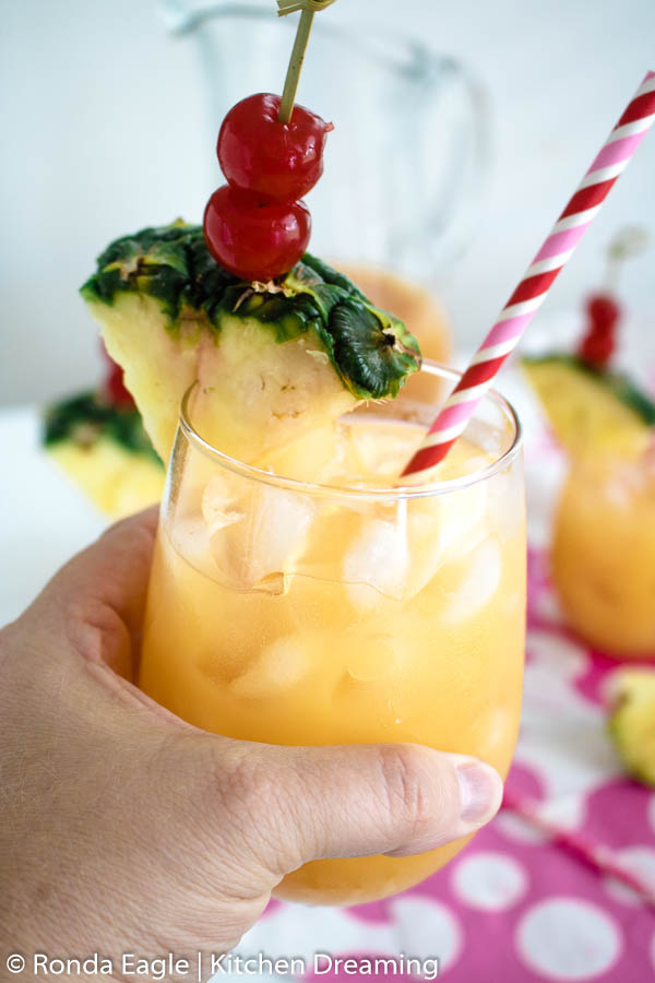Cheers! A toast is being made with a glass of Caribbean rum punch. 
