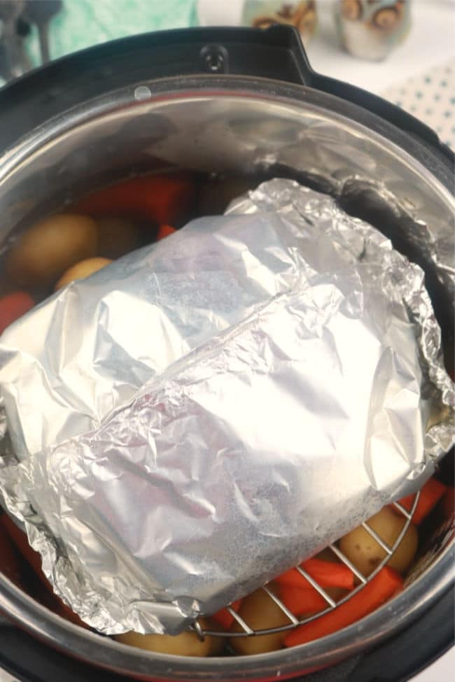 the meatloaf packet loaded into the Instant Pot in an aluminum foil packet.