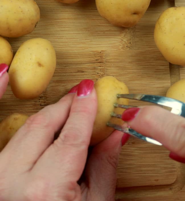 A photo of baby Dutch yellow potatoes being pierced with a fork. 