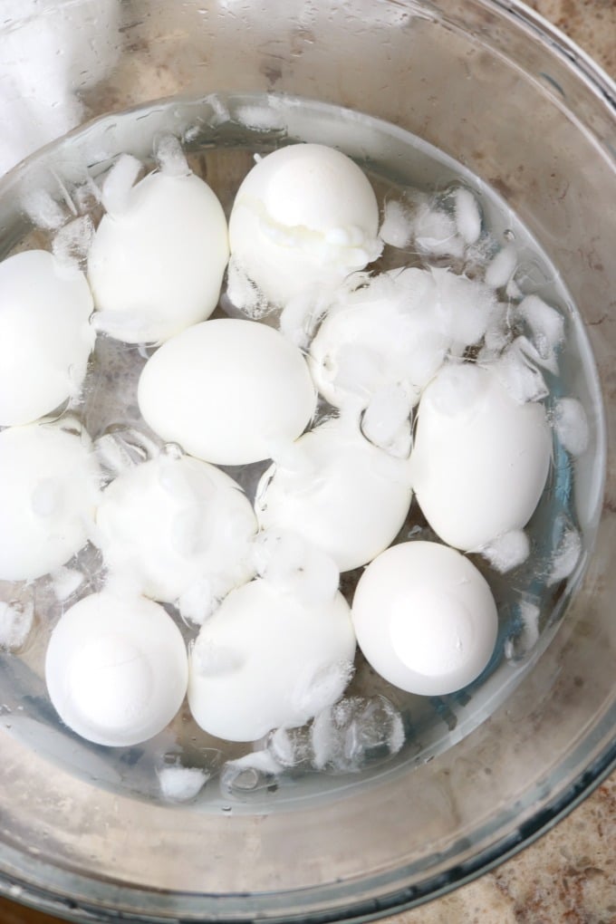 a bowl of ice water with hard boiled eggs inside