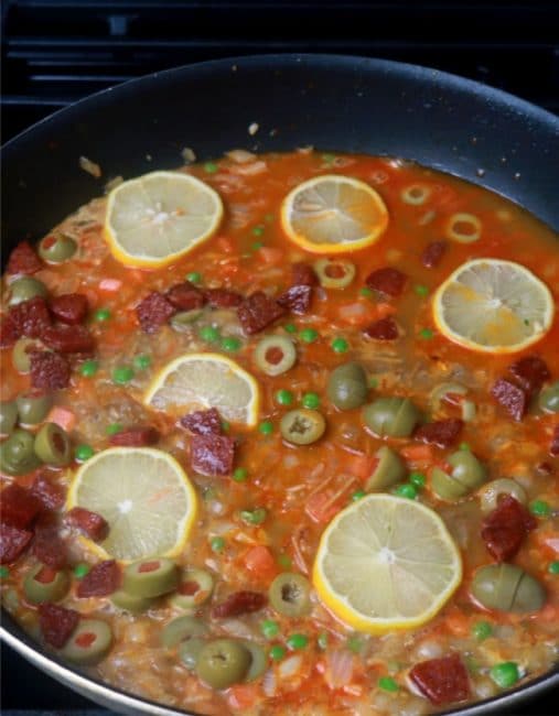 A simmering skillet filled with the ingredients for the pilaf base.