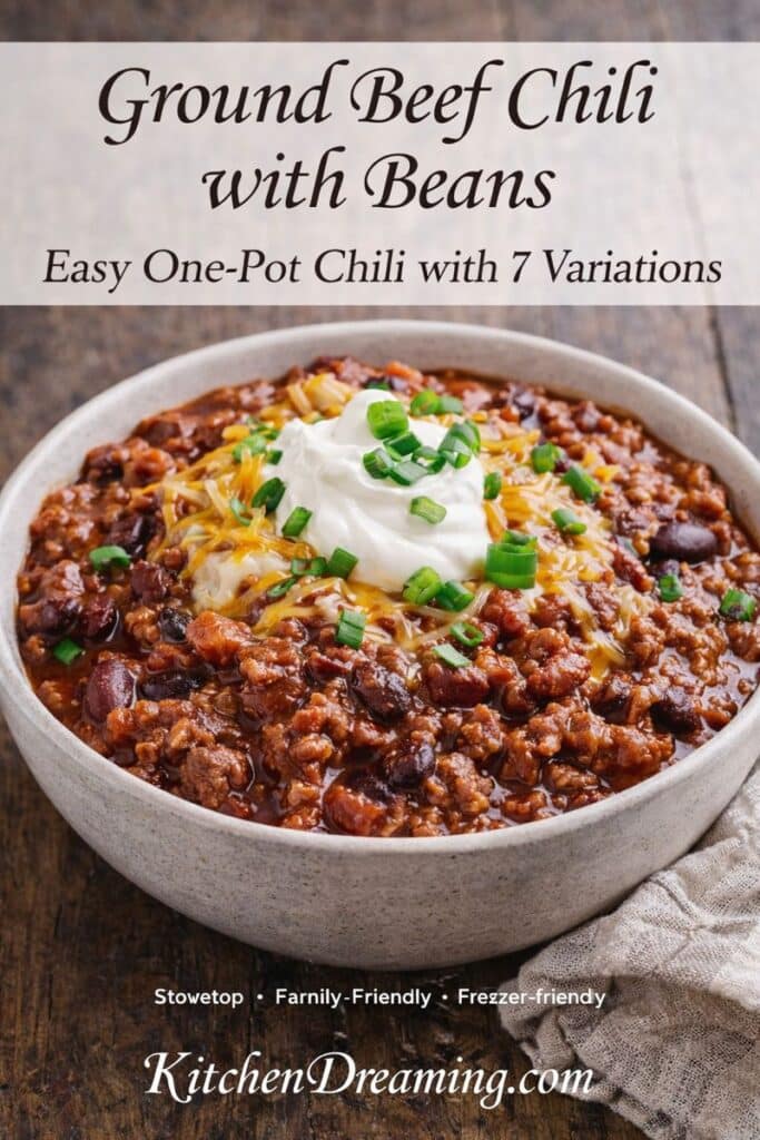 Bowl of ground beef chili with beans topped with cheese and sour cream.