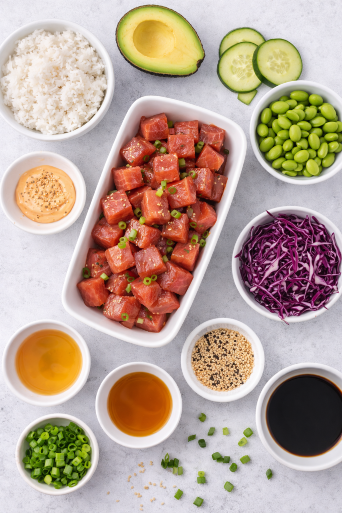 Easy Ahi Poke Bowl Recipe (Hawaiian Style Tuna Bowl) 2 Ahi Poke Bowl Recipe ingredients, tuna cubes, rice, avocado, cucumber, edamame, sesame seeds, and soy sauce