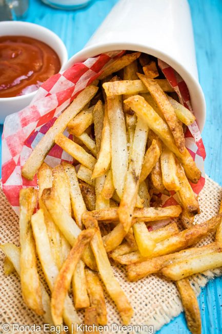 An up close image of air fryer French fries. crispy and brown exteriors with fluffy interior.