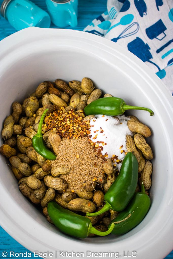 The ingredients for Crock Pot Cajun boiled peanuts are layered into the crock pot.