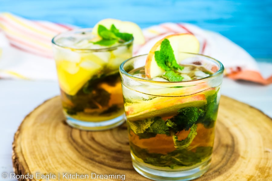Two apple mojitos on a wooden board. 