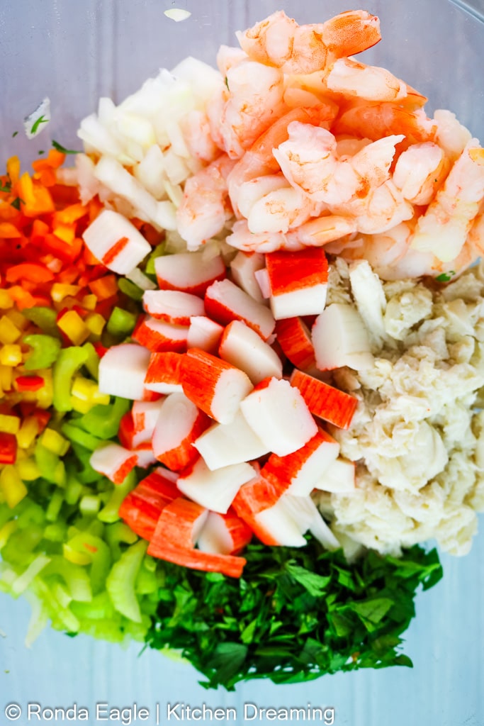 The ingredients for this seafood salad recipe layered into a bowl. The mayonnaise has not been added yet.