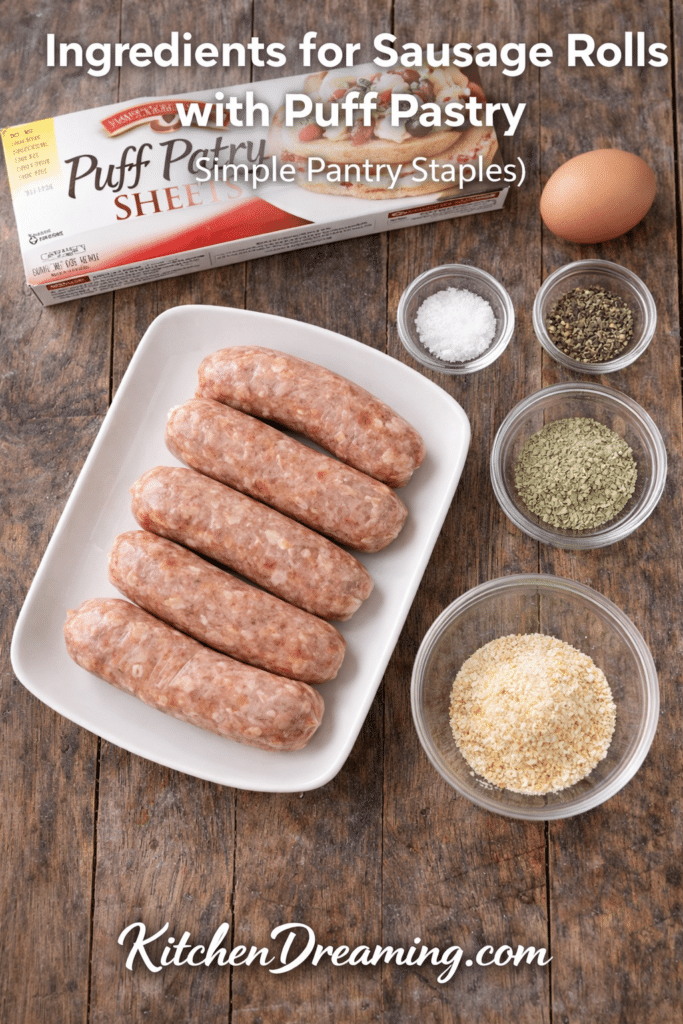 Ingredients for sausage rolls with puff pastry, including whole sausage links, puff pastry, seasonings, and egg wash.