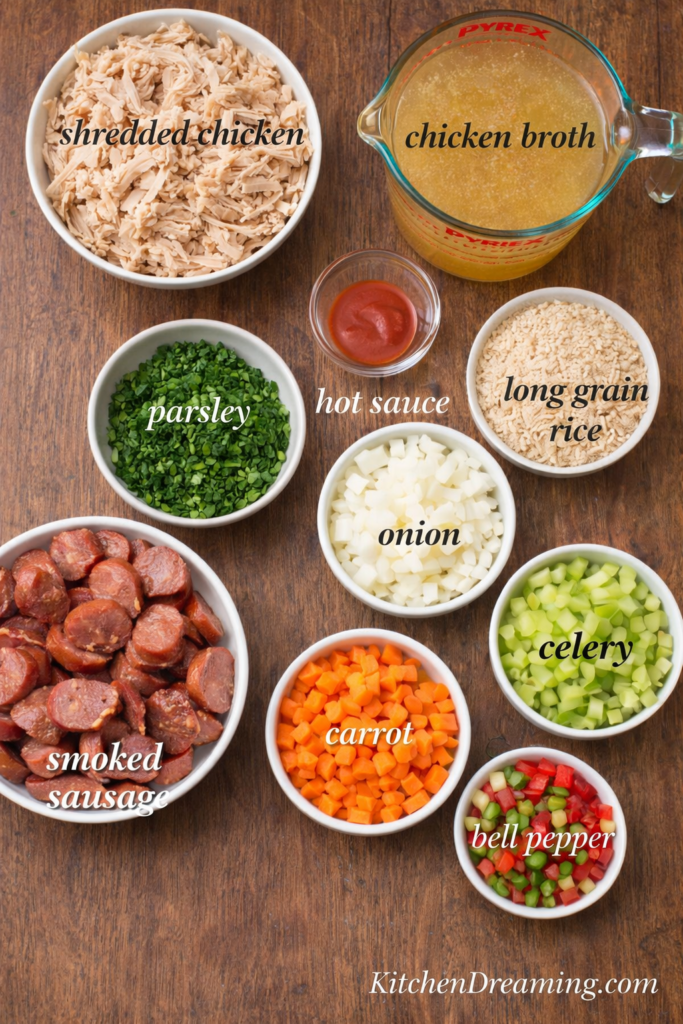 Chicken Bog Recipe (Lowcountry Chicken Pilau) One-Pot Southern Chicken and Rice 3 Ingredient flat lay for chicken bog recipe with labeled bowls of shredded chicken, smoked sausage, onion, celery, bell pepper, rice, broth, parsley, and hot sauce.