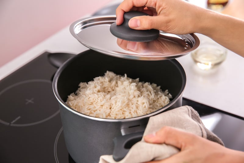 Cooked white rice in a pot after it's been fluffed with a fork.
