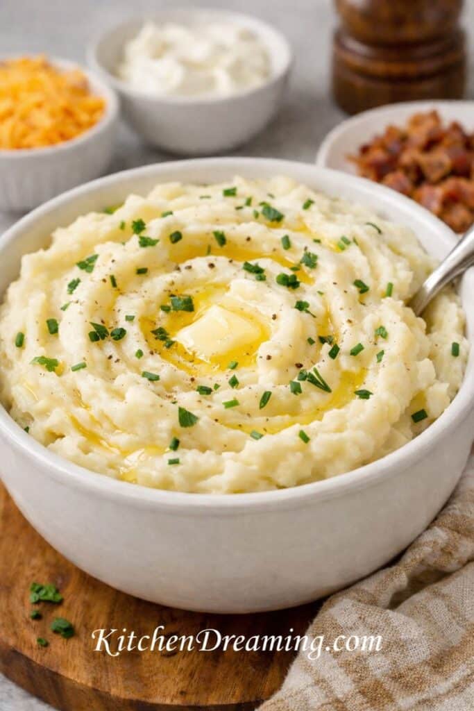 Instant mashed potatoes that taste homemade in a bowl with melted butter, herbs, and pepper.