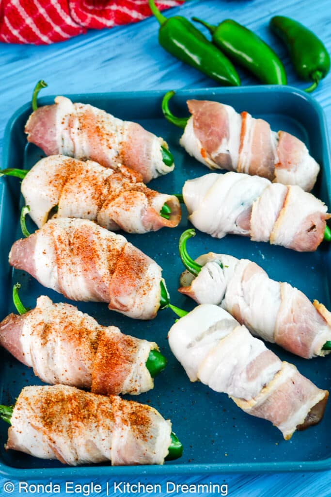 An in process photo of the bacon wrapped jalapeno poppers getting ready to go into the smoker.