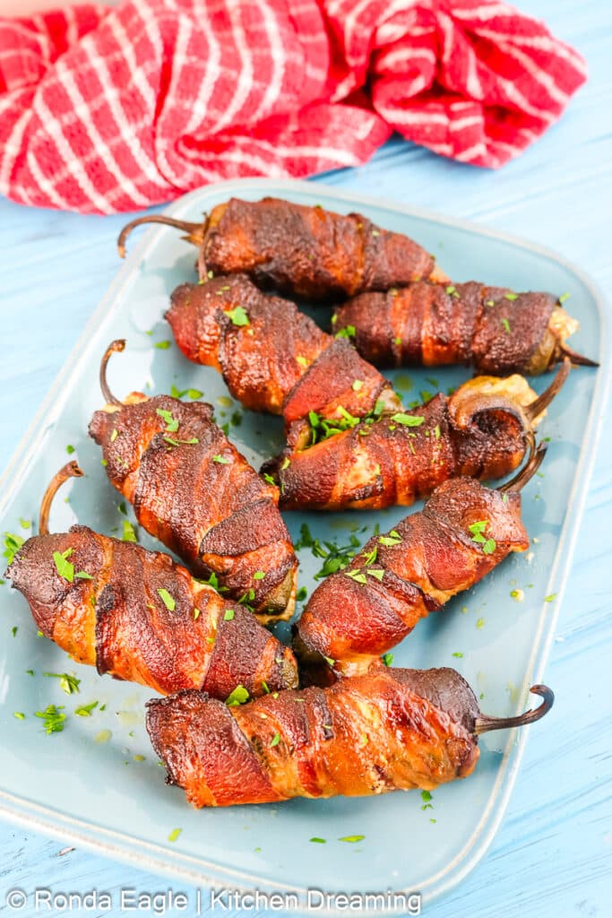 Smoked Jalapeno Poppers combines crispy bacon, roasted garlic cheese blend, and spicy jalapenos to create a mix of savory, smoky, and spicy flavors in every bite.