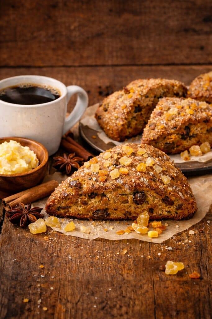 gingerbread scones with molasses and crystallized ginger on rustic farmhouse plate, bakery style winter breakfast scones.