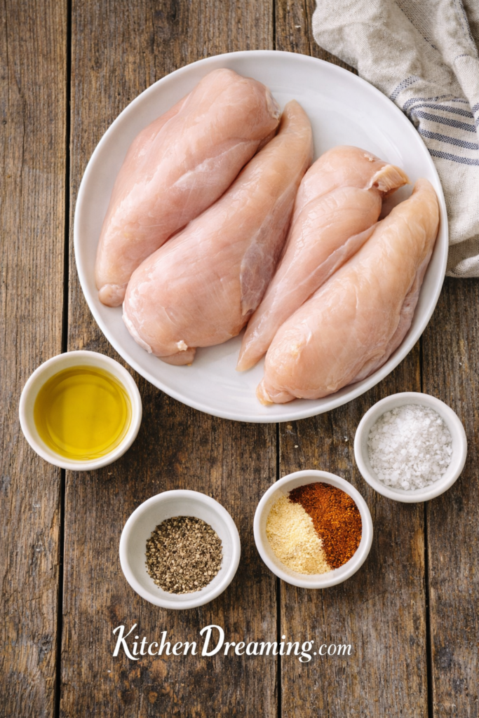 Chicken Meal Prep for the Week: One Simple Method, Endless Meals 2 Ingredients flat lay for chicken meal prep for the week including chicken breasts and seasonings.