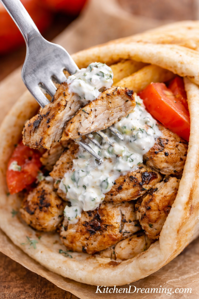 Chicken Gyro Meat Recipe Better Than Takeout 5 Close up fork bite of juicy chicken gyro meat with tzatziki inside warm pita bread.