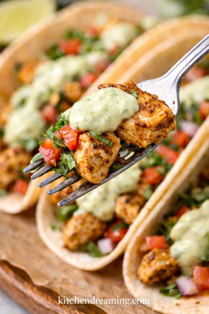 Creamy Jalapeno Sauce (Better Than Taco Bell) 5 Fork bite of grilled chicken taco topped with a small dollop of creamy jalapeno sauce, showing smooth taco truck green sauce texture.