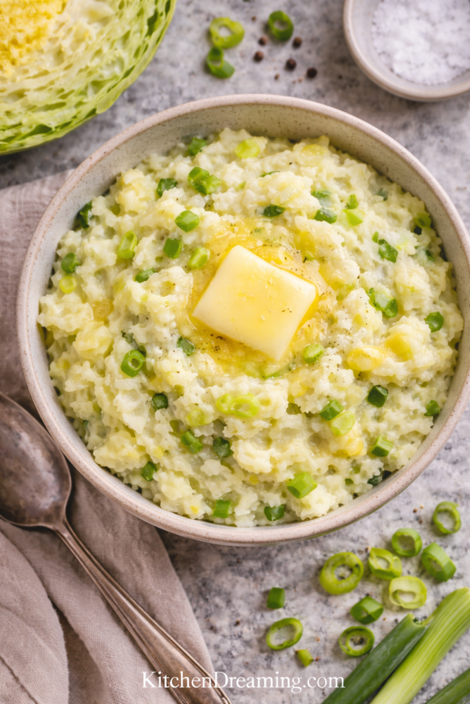 Traditional Irish Colcannon Recipe with Cabbage and Yukon Gold Potatoes 6 Traditional Irish colcannon recipe overhead texture shot with butter, scallions, and cabbage.