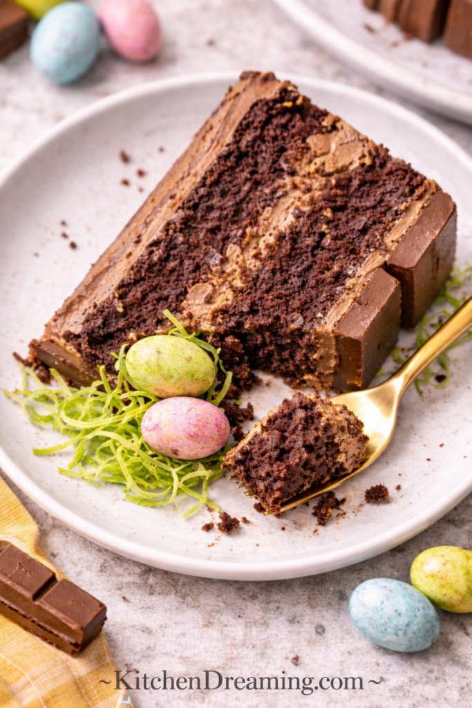 Easy Kit Kat Cake Recipe (Stunning Easter Basket Cake with Candy Eggs) 6 close up bite of kit kat cake slice showing moist chocolate crumb and frosting texture.