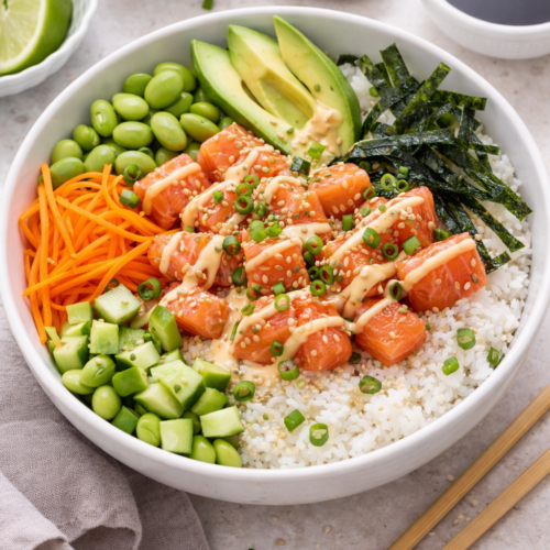 Salmon sushi bowl recipe with rice, avocado, cucumber, and sesame seeds.
