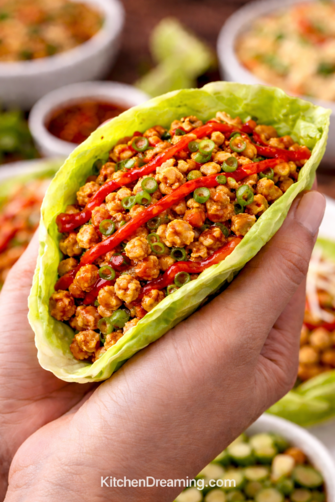 PF Chang’s Ground Chicken Lettuce Wraps (Better Than Takeout, Easy & Customizable) 6 PF Chang’s chicken lettuce wraps close up handheld with saucy ground chicken filling.